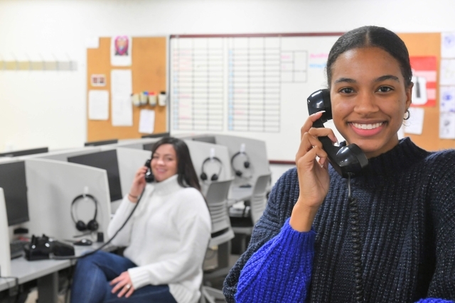 Two female students on the telephone in a call center