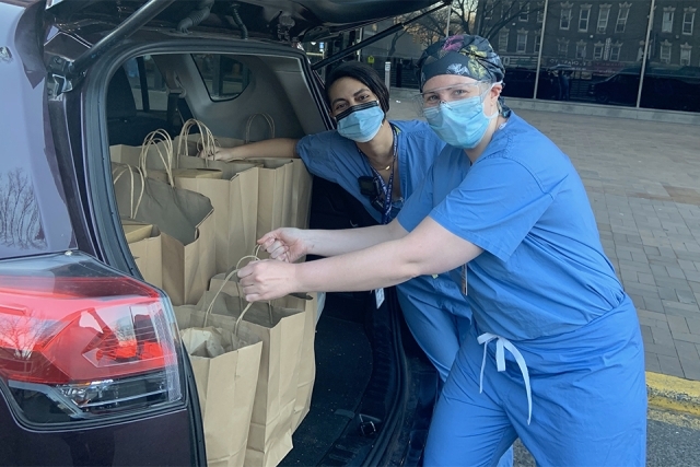 Healthcare workers getting food out of car trunk