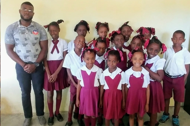 Male standing with a group of students 