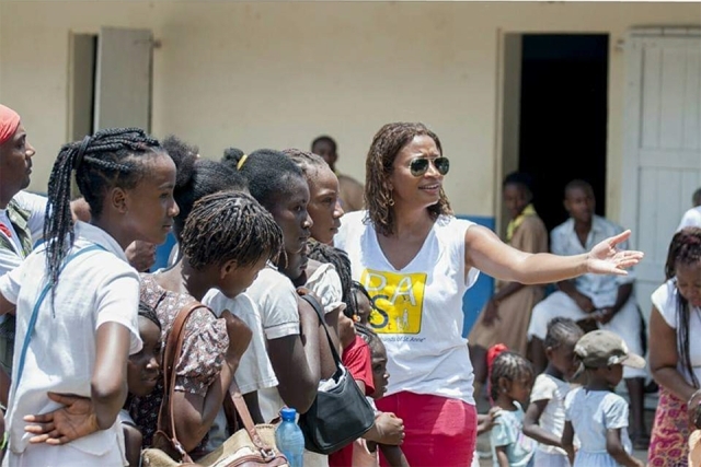 Female pointing while standing in crowd of students