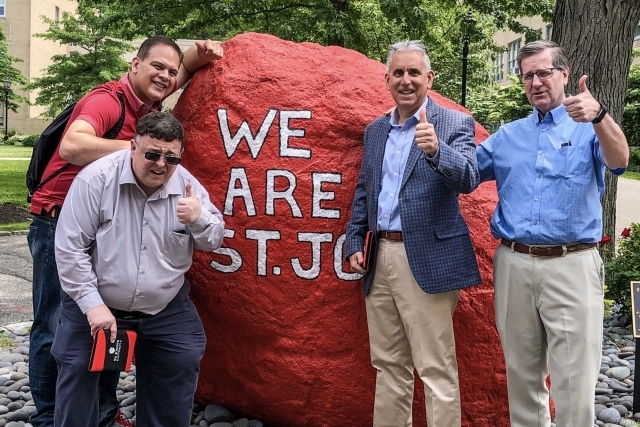 4 Men standing infront of We Are St. John's Sprit Rock