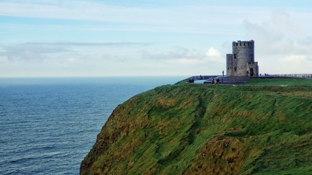 Irish castle on a green cliff by the sea