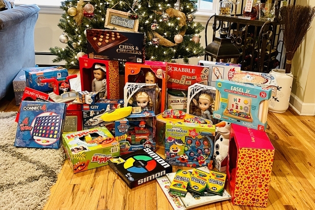 Collection of toys on the floor in front of a Christmas tree