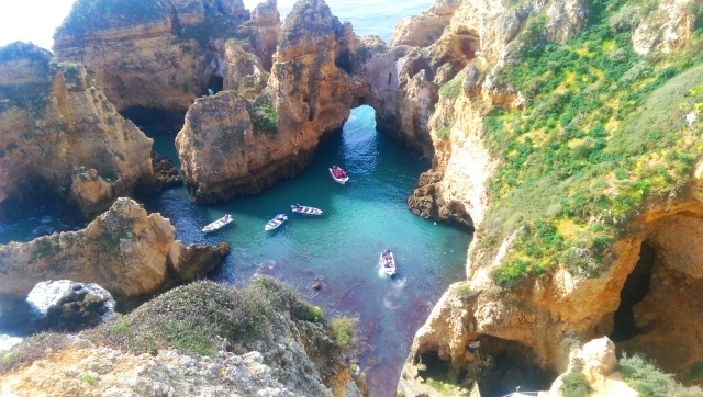 a view from above of boats in water surrounded by cliffs