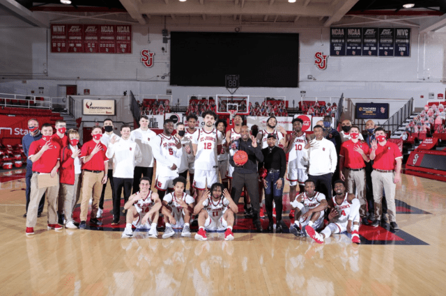 Head Coach Mike Anderson and the team pose for a picture celebrating Anderson's 400th Career Victory