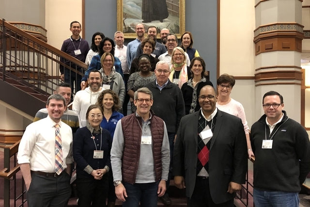 VMI members pose for a picture in front of a portrait of St. Vincent de Paul
