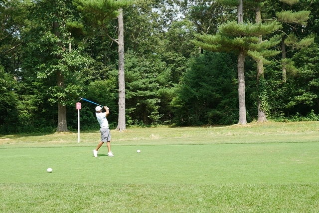 St. John's alumni and friends playing golf outside on the course