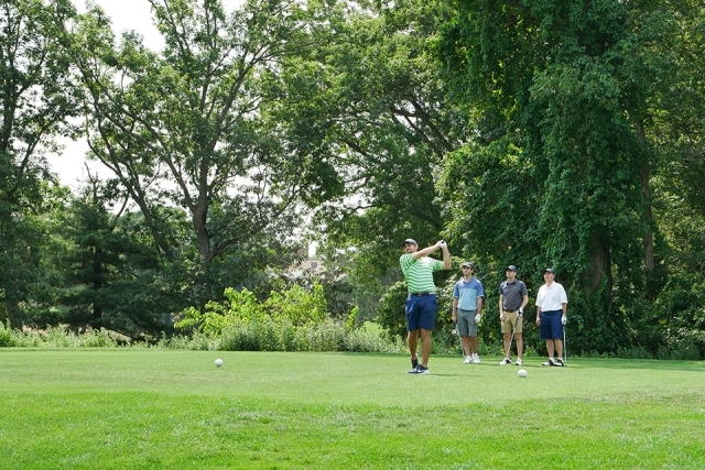 St. John's alumni and friends playing golf outside on the course