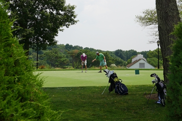 St. John's alumni and friends playing golf outside on the course