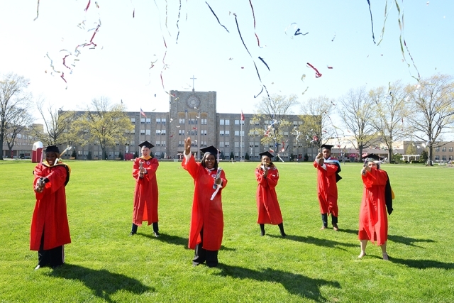 Students on campus in graduation robes
