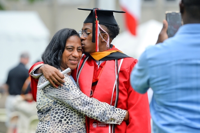 A graduate poses for a photo with his mother