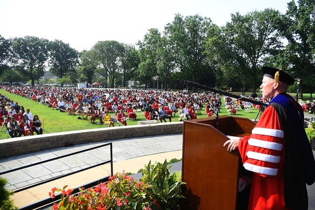 Fr. Shanley at podium looking over Great Lawn filled with graduates and families