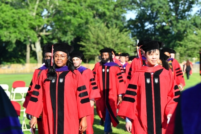 St. John's Law Class of 2020 graduates in red regalia and black tams