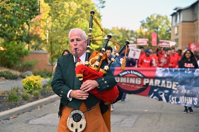 Man playing bap pipes in front of parade