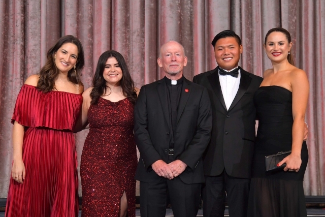 5 individuals standing on stage posing 