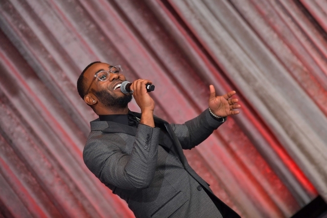 male singing into microphone on stage