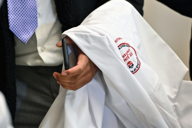 White coat folded over a student's arm