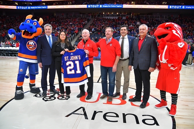 Leaders from St. John's, UBS Arena and the NY Islanders posing for photo at center court with mascots