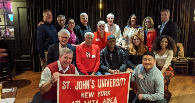 Group of Alumni holding St. John's University Alumni banner