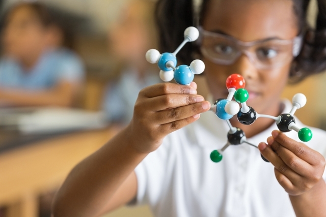 Girl holding science tool model 