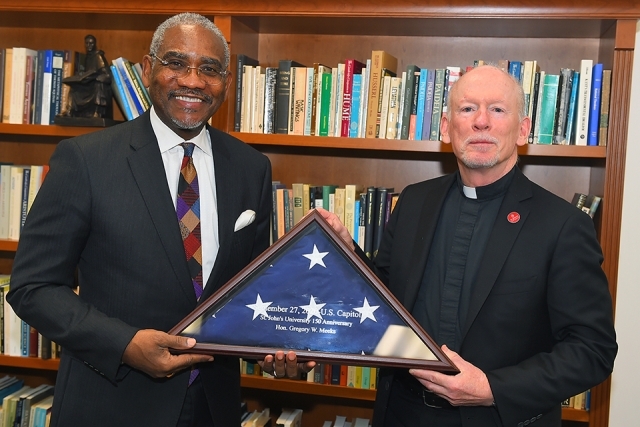 Rep. Greg Meeks Visits Queens Campus to meet with Fr. Shanley while holding American flag