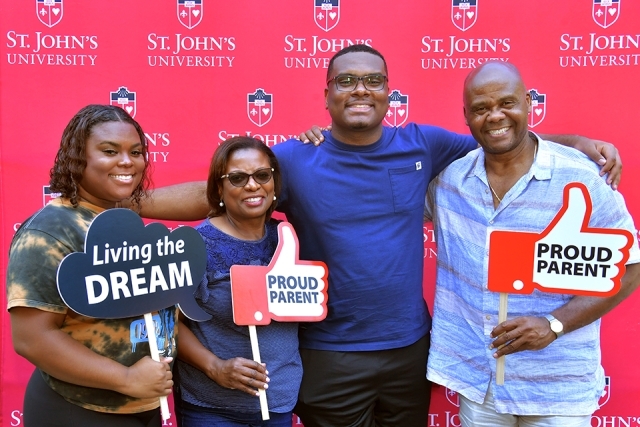 Student and family members at Move In Day in front of step and repeat