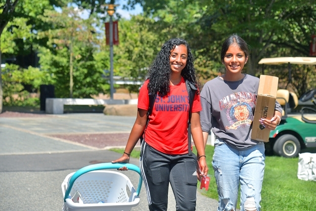 Students walking with their stuff at Move In Day