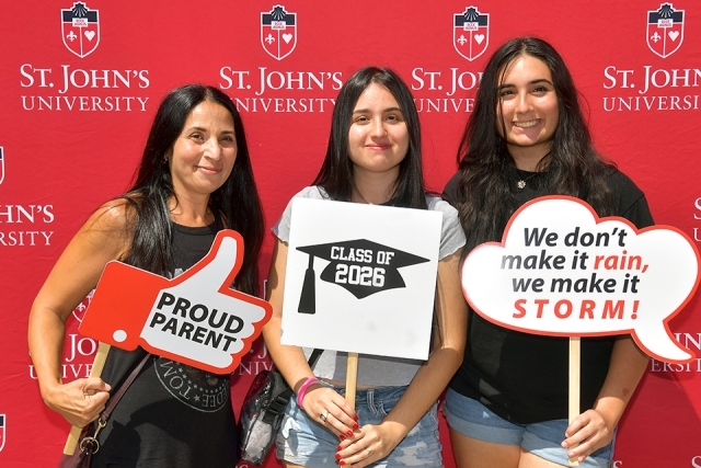 Students pose for a photo in front of St. John's step and repeat