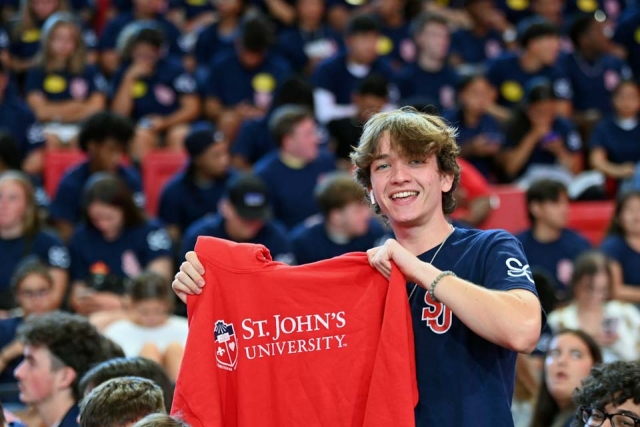 Student holding up St. John's sweatshirt at 2022 New Student Convocation in Carnesecca