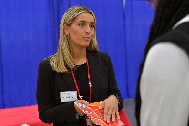 Female recruiter speaking with student at career expo