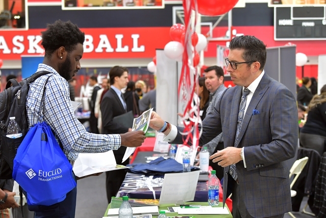 Two males speaking together at career expo