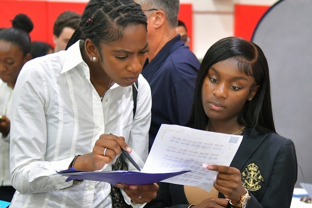 Two females reviewing resume at career expo