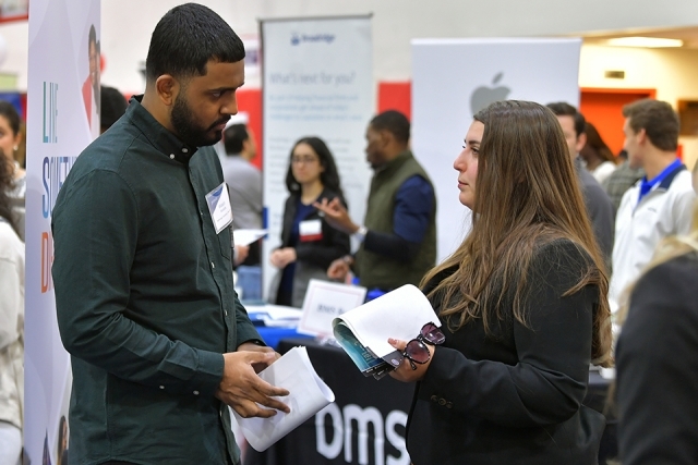 A male and female speaking to one another at career fair