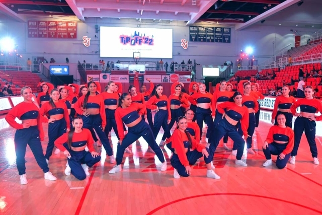 The dance team posing for a photo on the court 