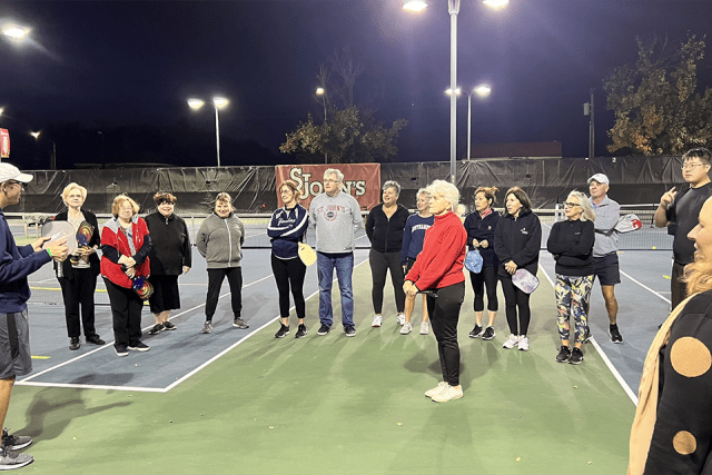 Alumni on the pickleball courts at night