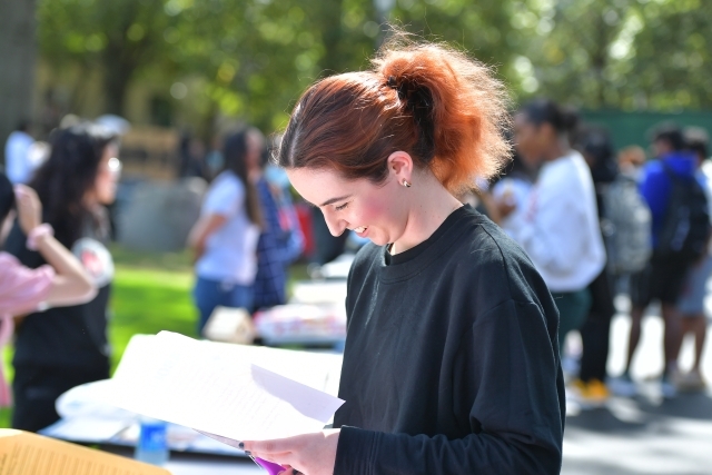 Student looking at paper smiling 