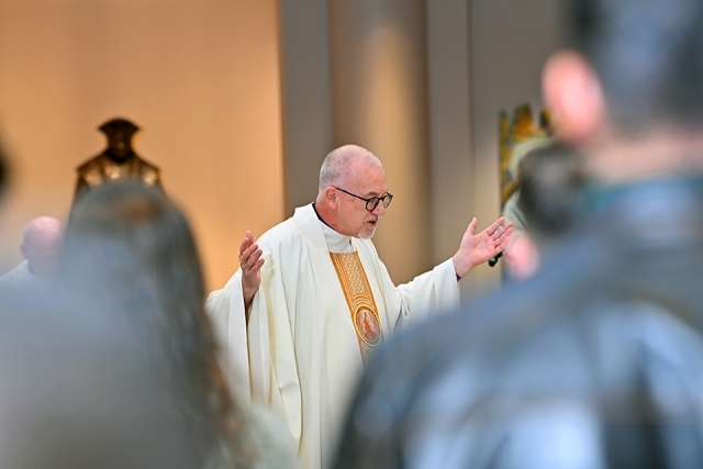 Fr. Rooney with hands outstretched