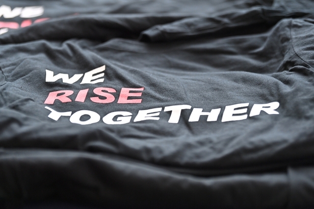 We Rise Together T-Shirt on Table