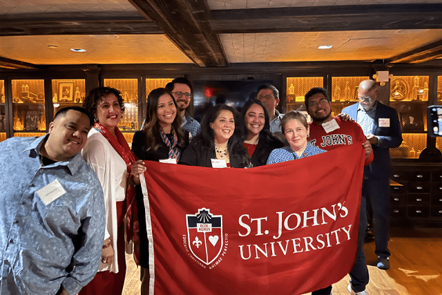 Alumni holding up St. John's University banner