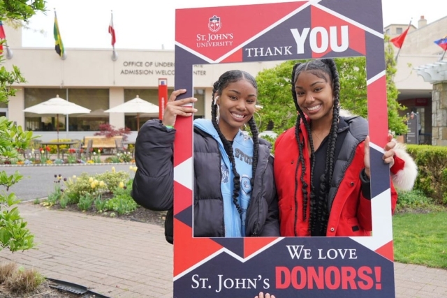 St. John's Students holding a Thank A Donor Sign on great lawn