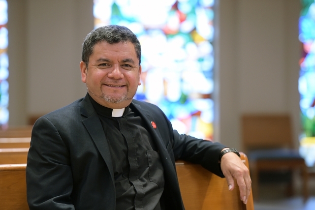 Fr. Hugo Medelin sits in a pew in St. Thomas More church