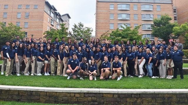 A group photo of the Residence Life staff in front of the village