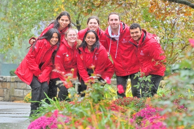 Admissions ambassadors in red jackets posing for a photo outside