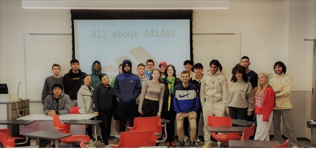 Dr. Bushati (front, sixth from left) with her GOLE project students from ECO 1002 standing in front of projector screen that says "All About Adidas"