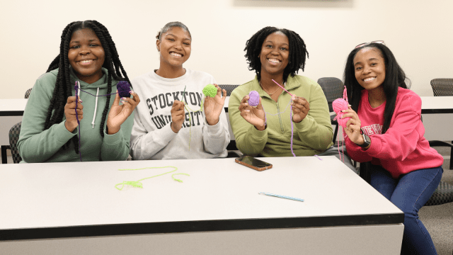 Four students at a Student Services crochet event during Wellness Week.