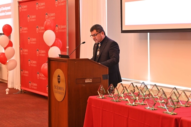 Male speaking at the podium at the 2024 Training and Development Certificate Graduation