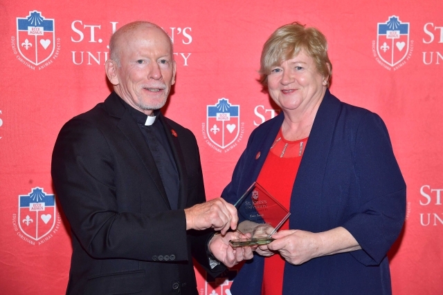 Fr. Shanley handing award to 2024 Training and Development Certificate Graduate