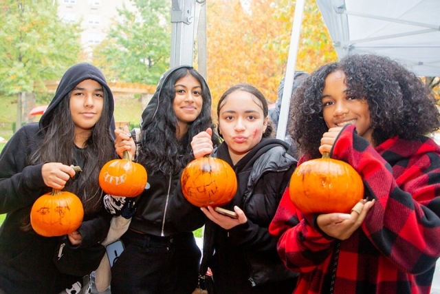 Group of people holding pumpkins during St. John's Homecoming Weekend 2023 