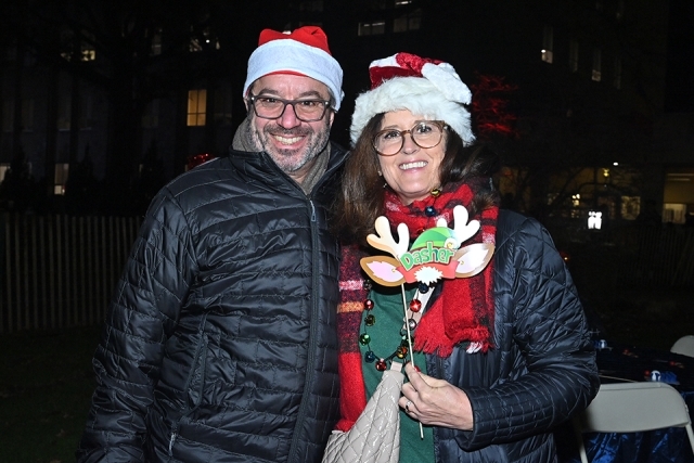 Male and female posing for photo holding reindeer antlers