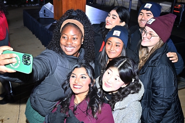 A group of students posing for a photo at the St. John's Christmas tree lighting 